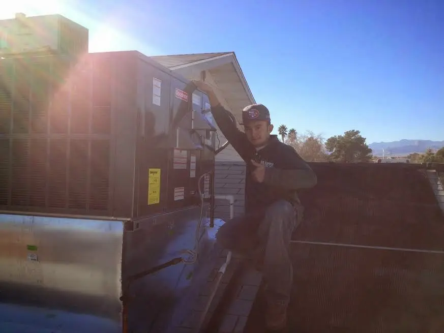HVAC technician performing AC Tune-Up on a rooftop unit in University Place